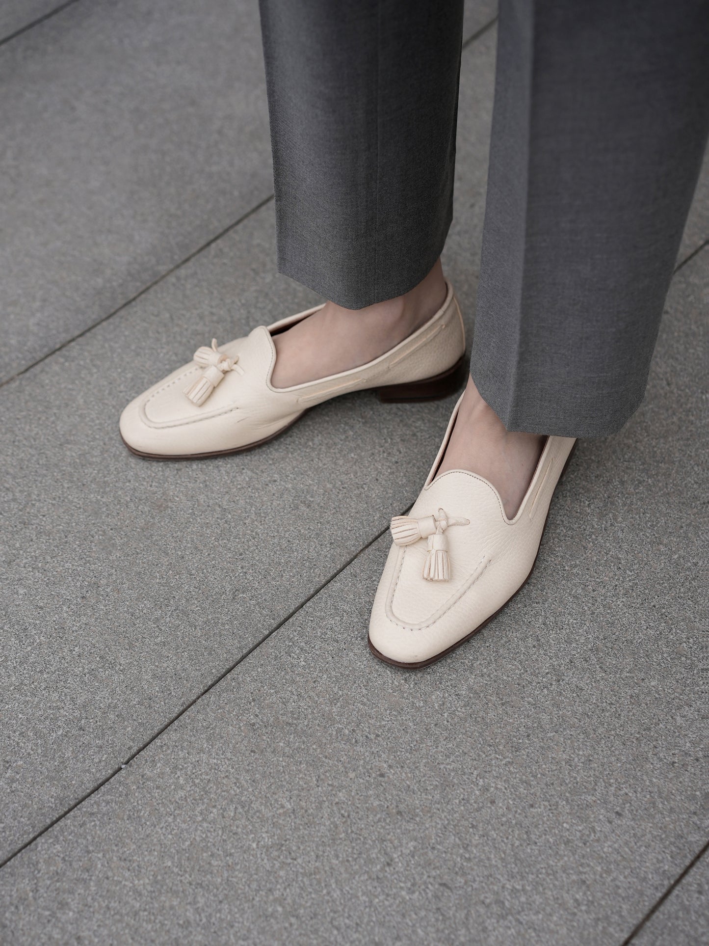 Moonland Ivy grey wool trousers, straight leg with sharp front crease and clean ankle length hem, styled with cream tassel loafers.