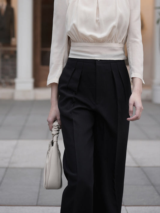 Moonland Monday worsted wool trousers in black, details on the top part, high-rise waist, straight cut with central pleat turning into a sharp crease.