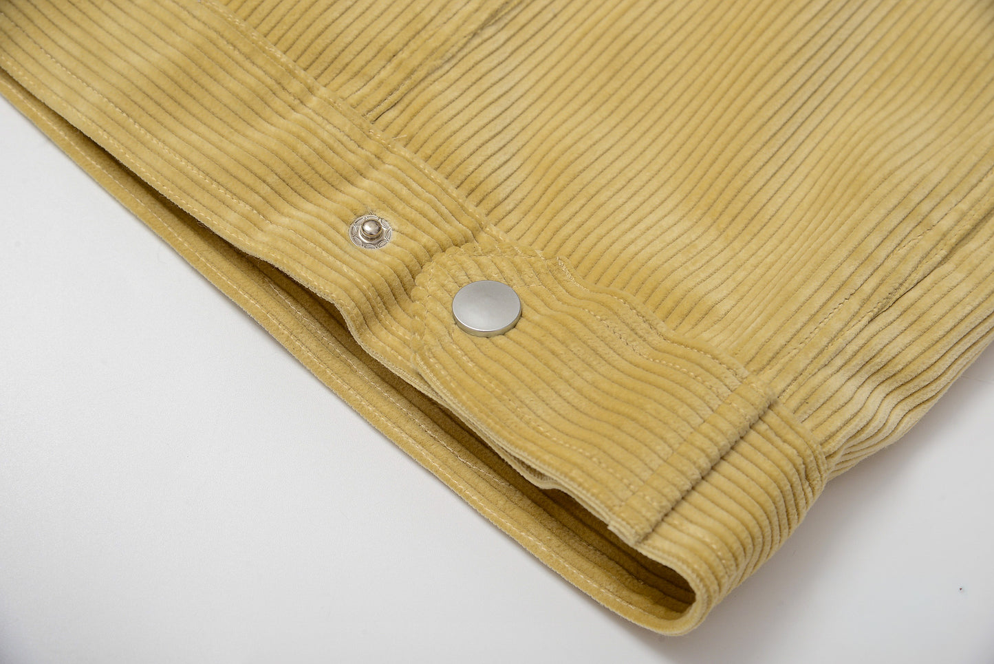 Close-up of a mustard yellow corduroy jacket on a white background #color_creamy-yellow