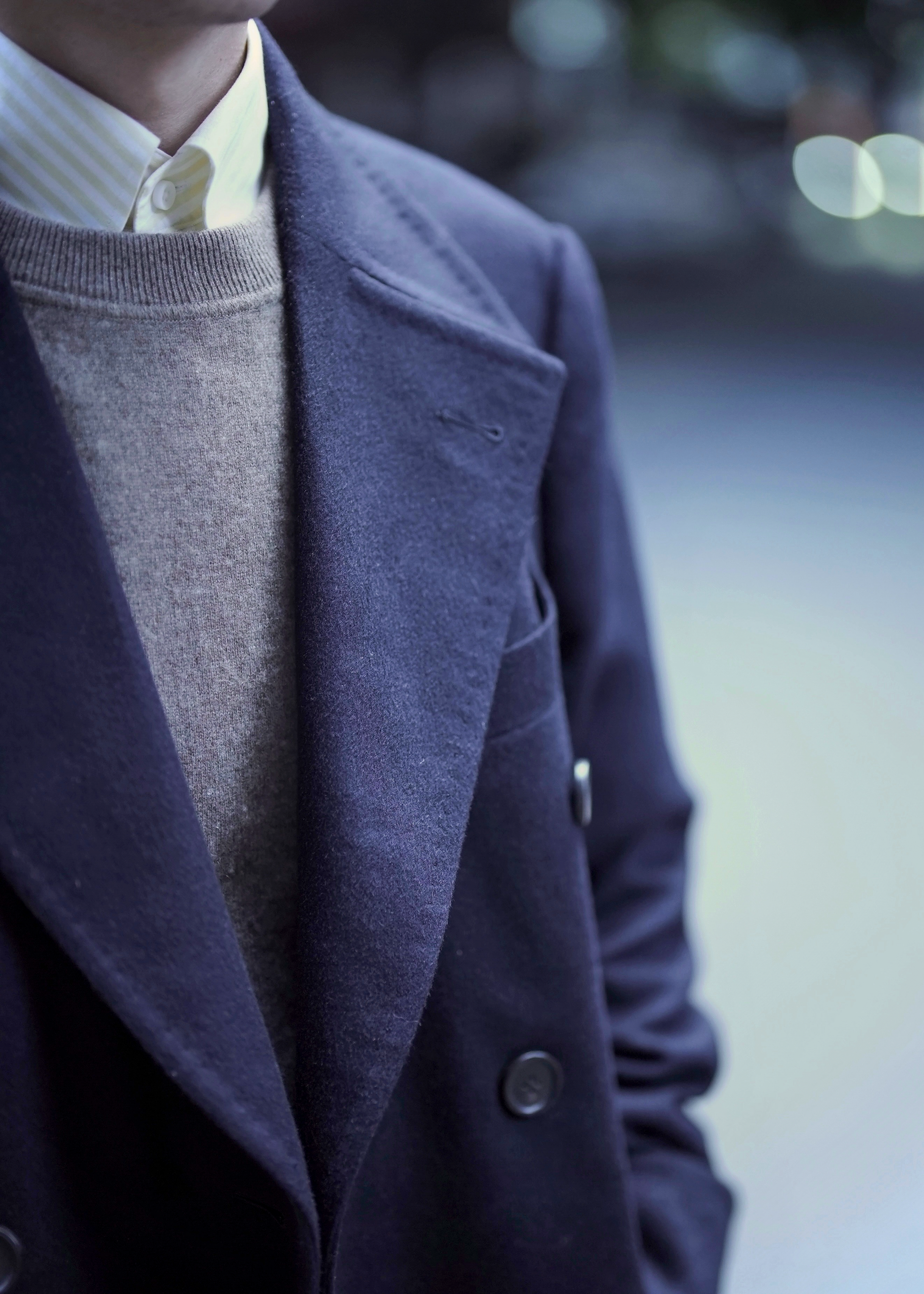 Close-up collar and lapel detail of Moonland's dark blue polo coat for men outdoors. fabric from Loro Piana cashmere