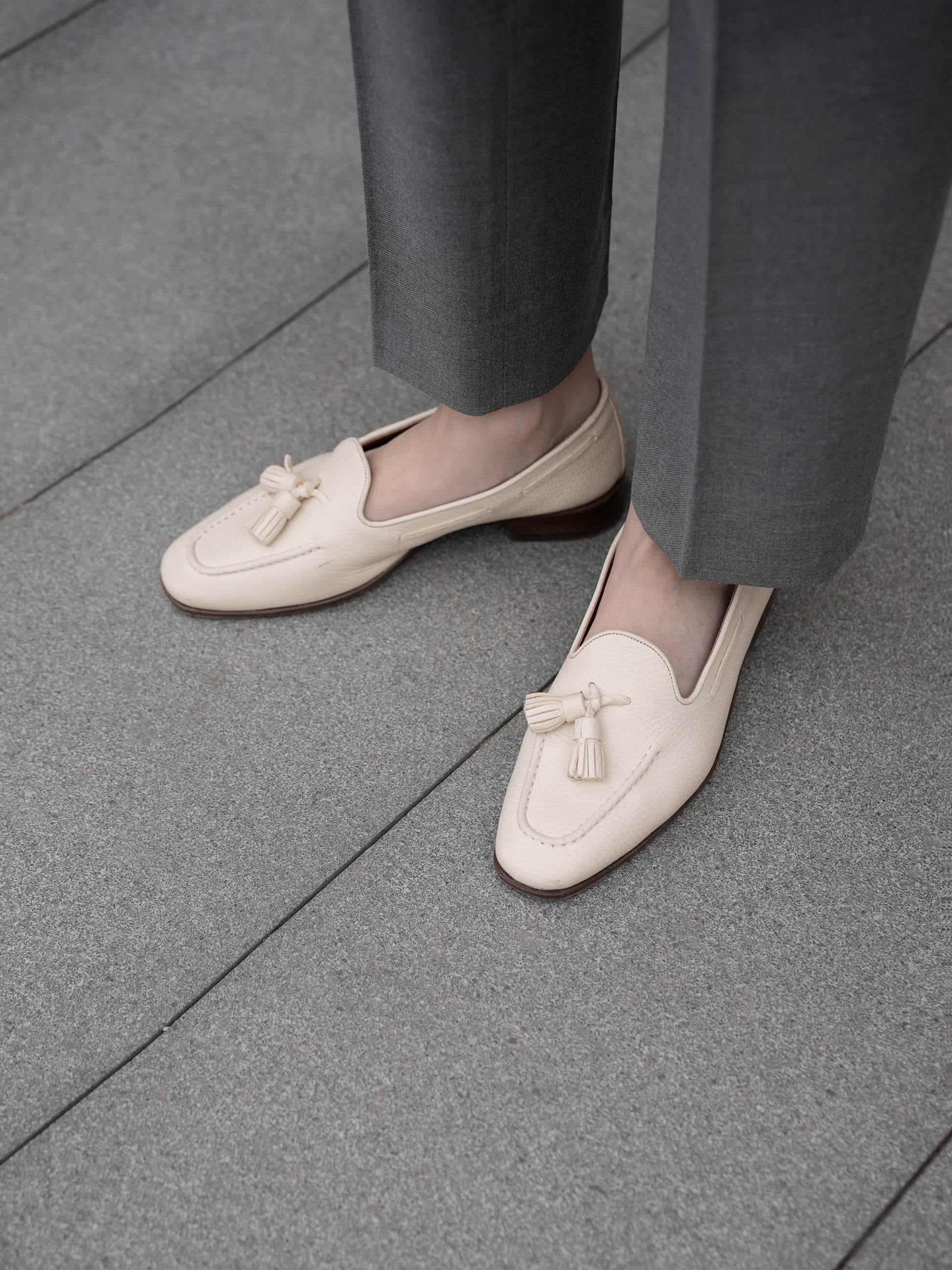 Moonland Ivy grey wool trousers, straight leg with sharp front crease and clean ankle length hem, styled with cream tassel loafers.