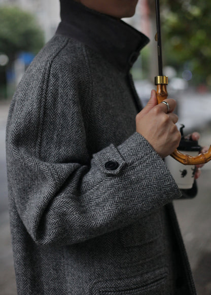 Close-up sleeve and pocket detail of Moonland's Balmacaan coat for men, made of Harris Tweed grey tone herringbone pattern. convertible collar with a durable sheepskin undercollar.