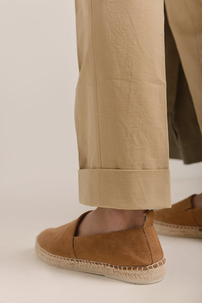 Model wearing Moonland Ivy Chinos in beige Roger Laviale cotton twill, close-up of cuffed hem paired with casual shoes.