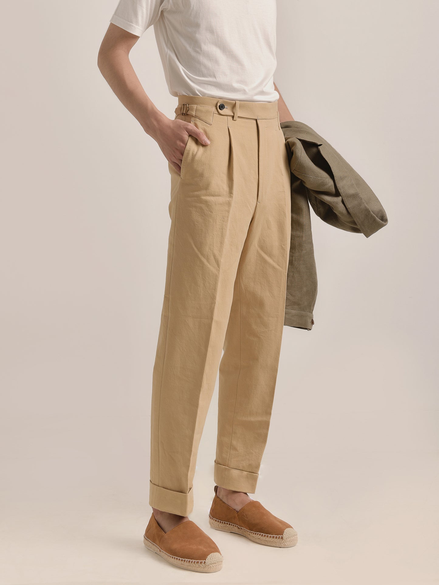 Side-front view of model in Moonland Ivy Chinos in beige Roger Laviale cotton twill, showing slanted pocket, side adjuster, and straight leg fit.