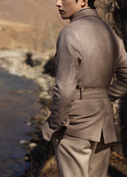 Back view of model wearing Moonland's Altai safari jacket for men, with belted waist and center back vent