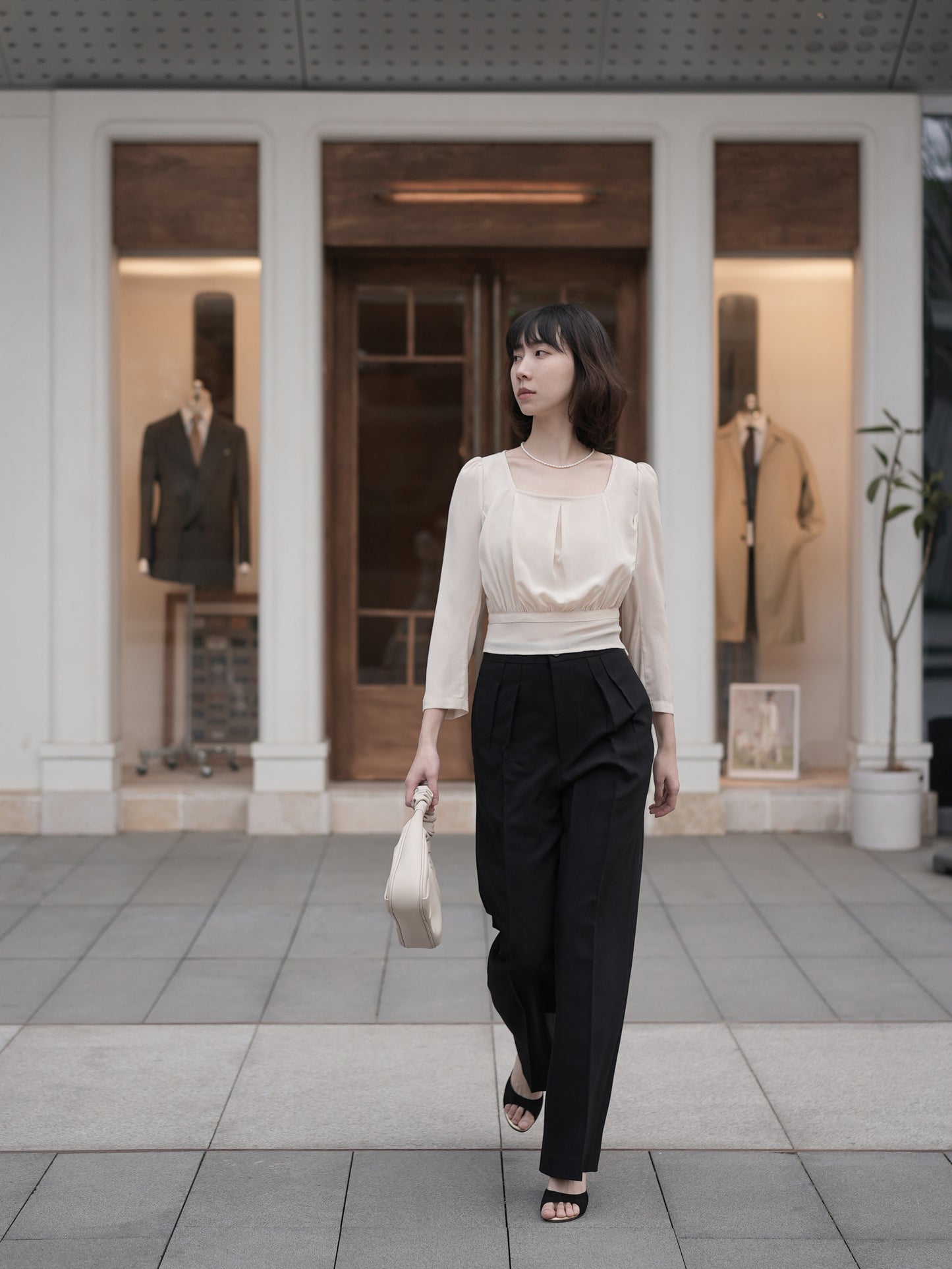 Moonland Monday worsted wool trousers in black, high-rise waist, straight cut with central pleat turning into a sharp crease.