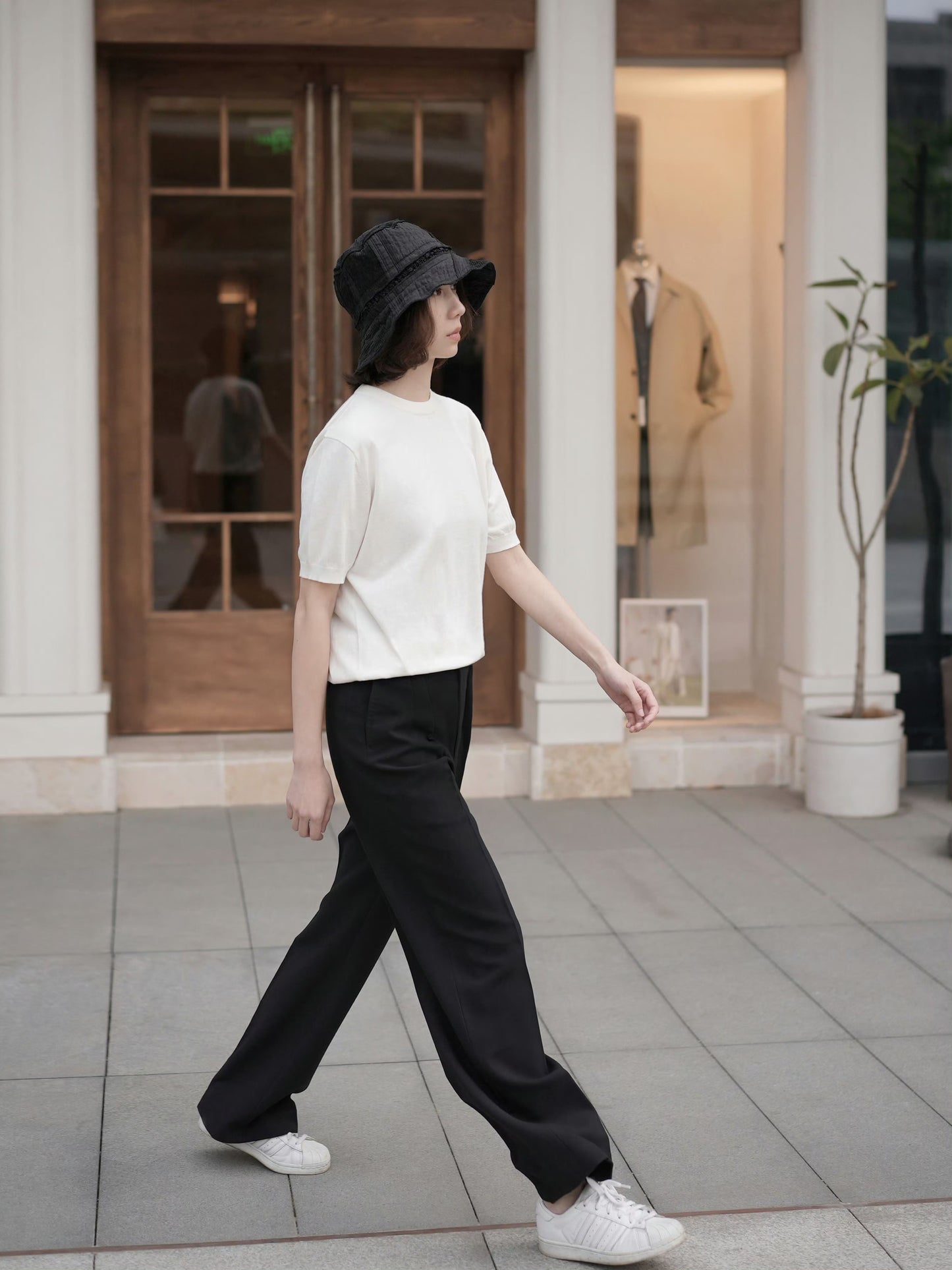 Moonland Monday worsted wool trousers in black, side view, high-rise waist, straight cut with central pleat turning into a sharp crease, casually pairing with a t-shirt and sneakers