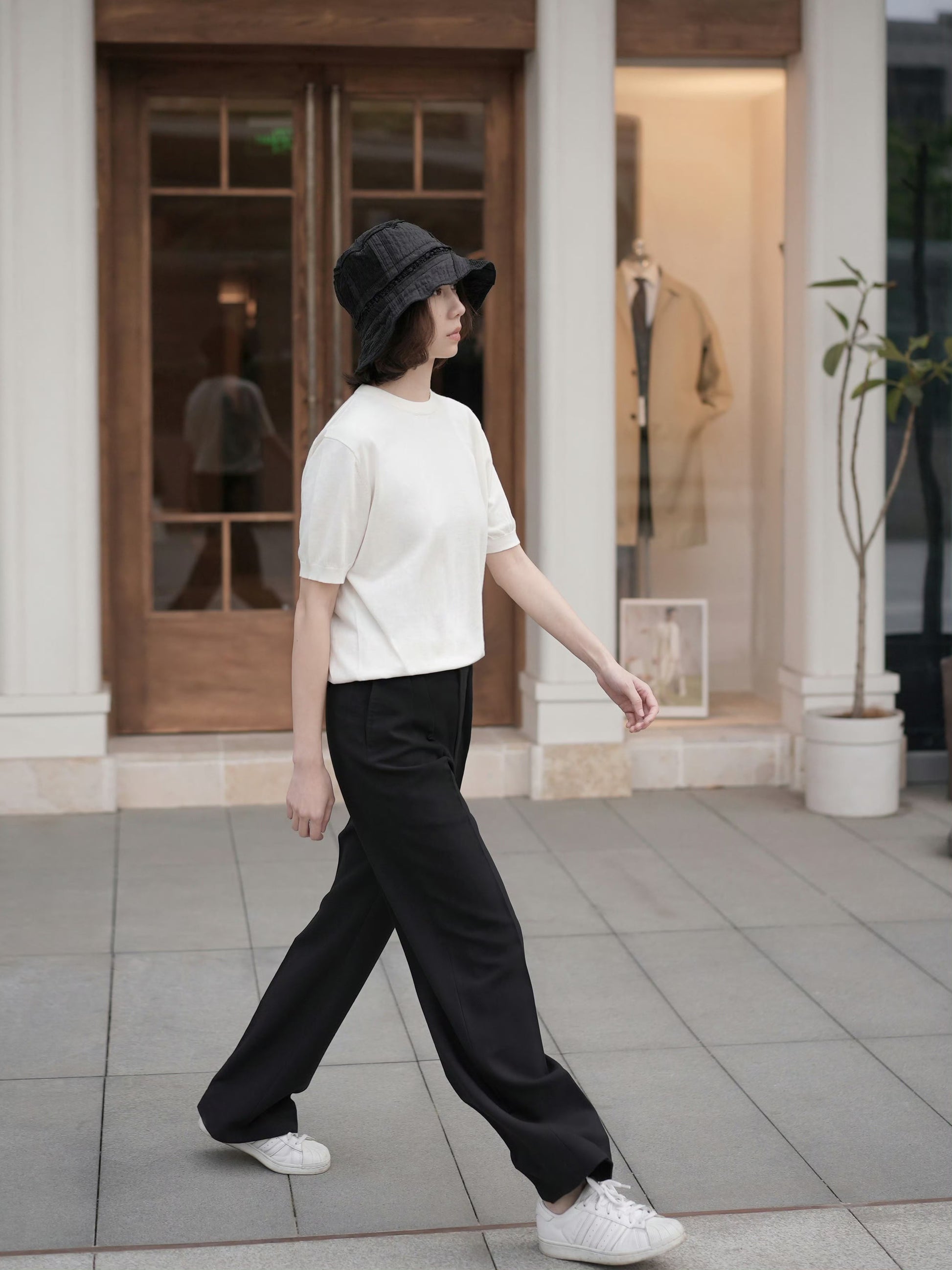 Moonland Monday worsted wool trousers in black, side view, high-rise waist, straight cut with central pleat turning into a sharp crease, casually pairing with a t-shirt and sneakers