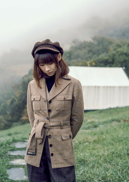 Moonland brown windowpane wool safari jacket front view, Ulster notch lapel, utility pockets with inverted pleats and defined waist with buckled belt.