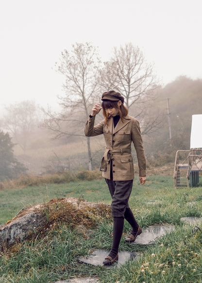 Moonland brown windowpane wool safari jacket side view, Ulster notch lapel, utility pockets with inverted pleats and defined waist with buckled belt.