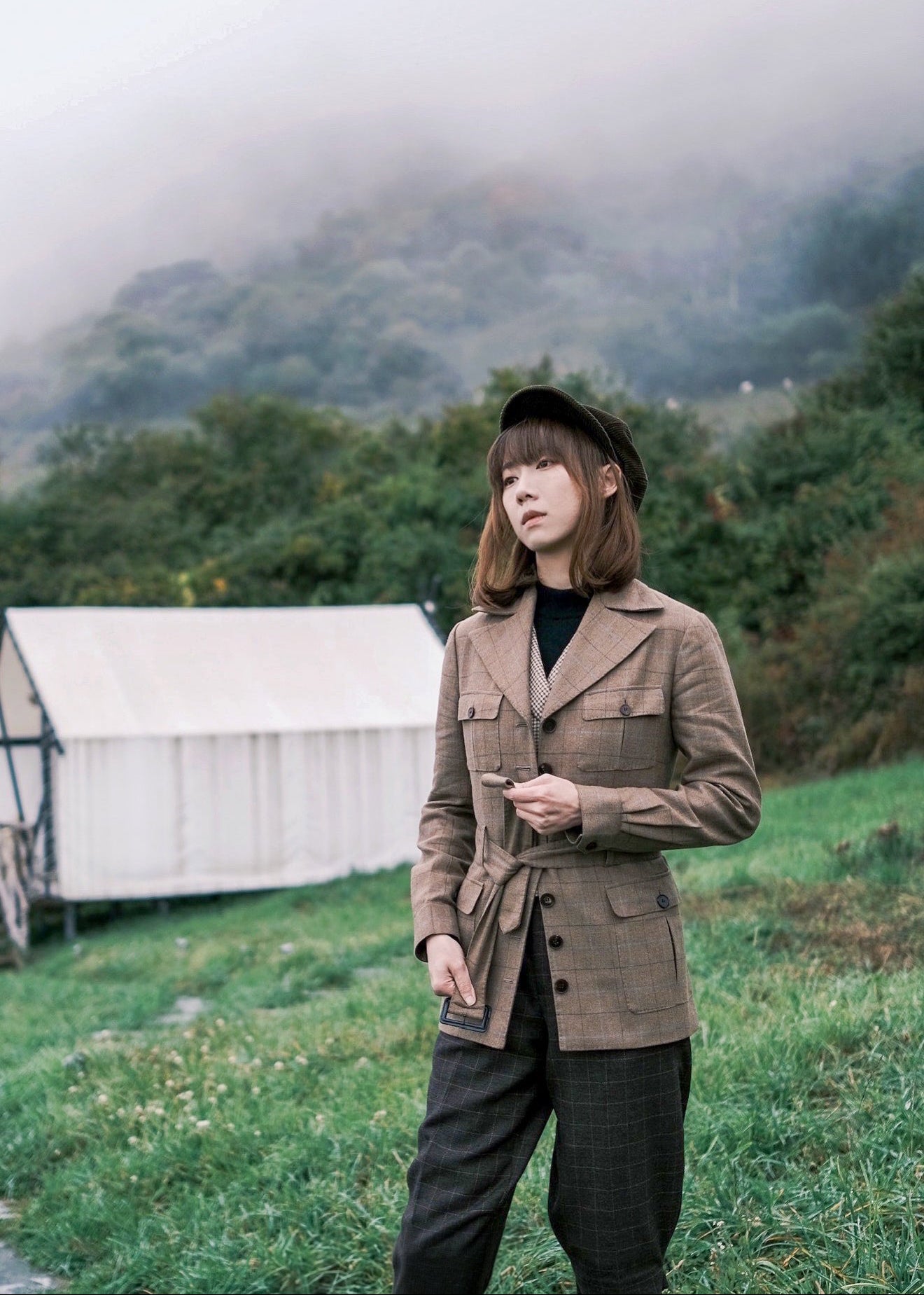 Moonland brown windowpane wool safari jacket side view, Ulster notch lapel, utility pockets with inverted pleats and defined waist with buckled belt.