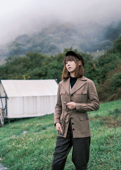 Moonland brown windowpane wool safari jacket side view, Ulster notch lapel, utility pockets with inverted pleats and defined waist with buckled belt.