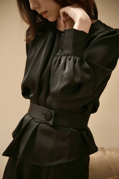 Moonland Silk Ripple Pleat Blouse, in black color, side front view with details, gathered round neckline, long puff sleeves with volume, cuff with covered round buttons, pleated peplum with self belt at the front and a large covered button, soft lustre 