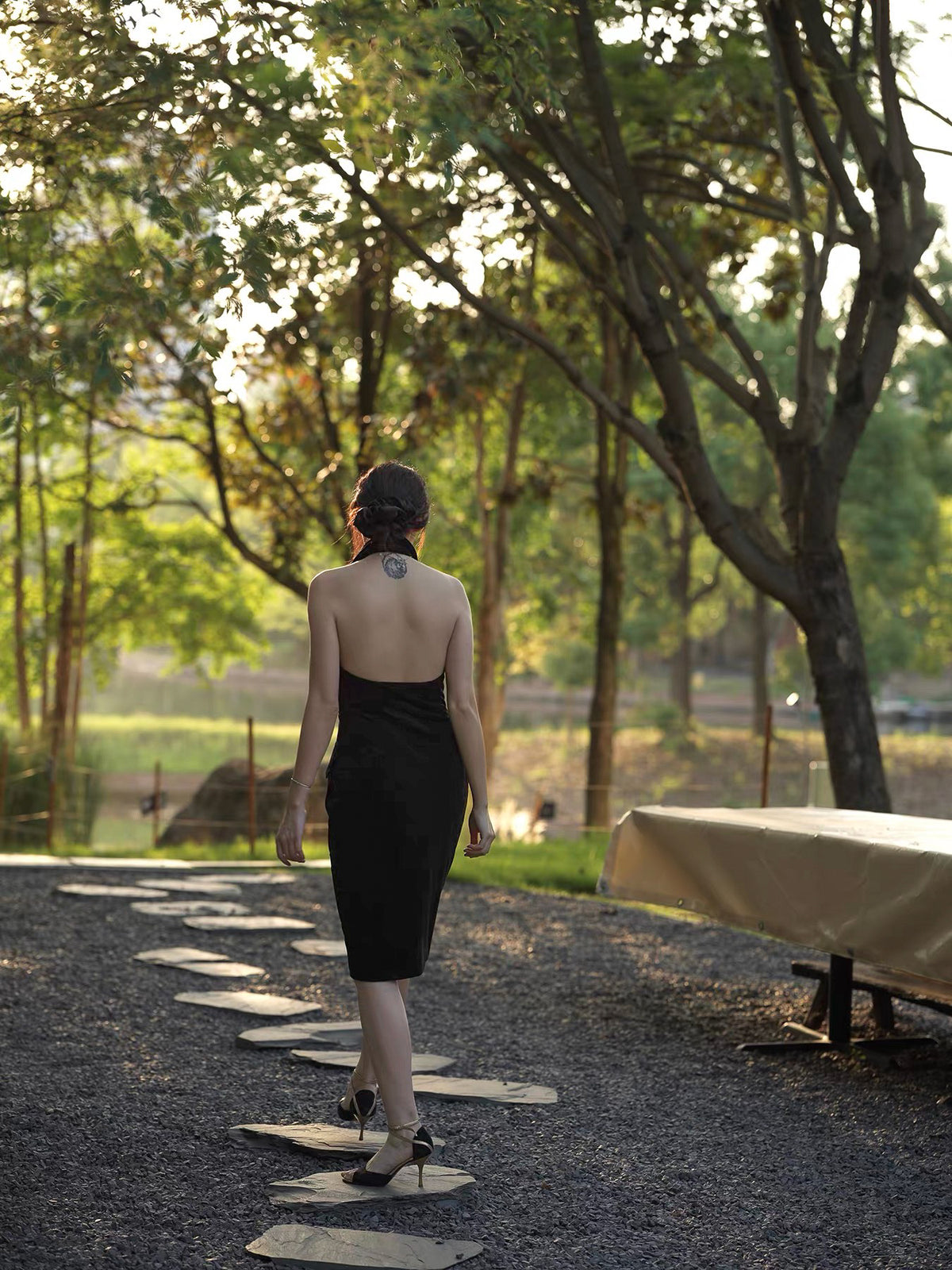 Moonland smoking velvet halter dress, black silk velvet, back view outdoors at sunset, open back, midi length, sheath silhouette
