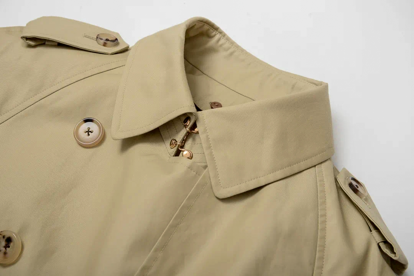 Close-up of a khaki trench coat with buttons on a white background #color_khaki #color_cypress-green